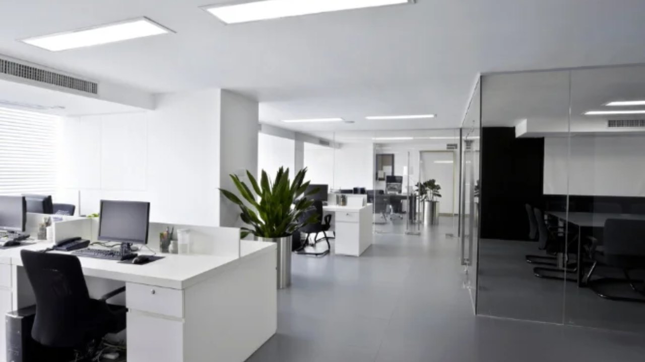 Clean, bright open-plan office with white desks and polished grey floor