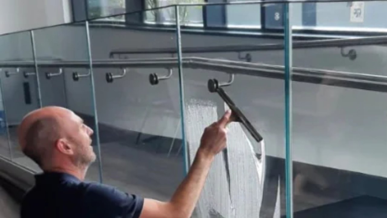 Supacleen cleaner using a squeegee on a glass balustrade
